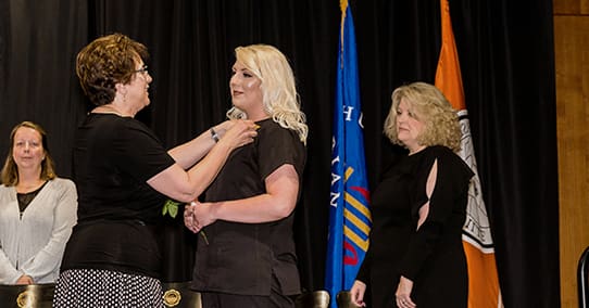 Nursing student receives her honorary pin for completing the nursing program.