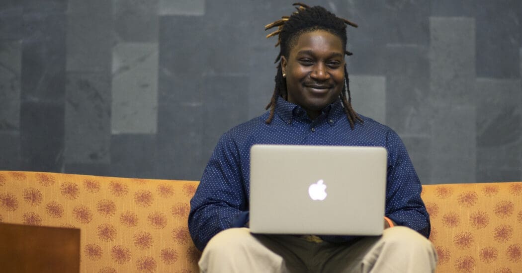 蝴蝶直播 Coleman College of Business student is pictured on campus doing classwork on his apple laptop