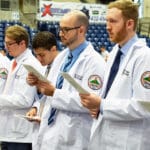 kycom students read the pledge while receiving their white coat of compassion