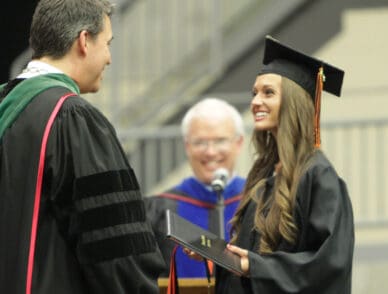 upike student greeted by university president dr. burton webb on stage at commencement