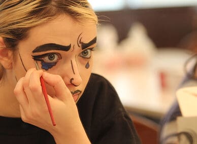 Student practices pop-art makeup during a stage make-up course.