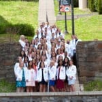 KYCO Class of 2021 students stand on the Historic 99 steps after receiving their white coats in April 2018