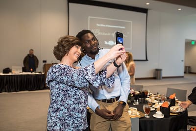 Associate Director of Advancement and Alumni Relations Lisa Blackburn poses for a selfie with UPIKE student Cheikh Ndaiye