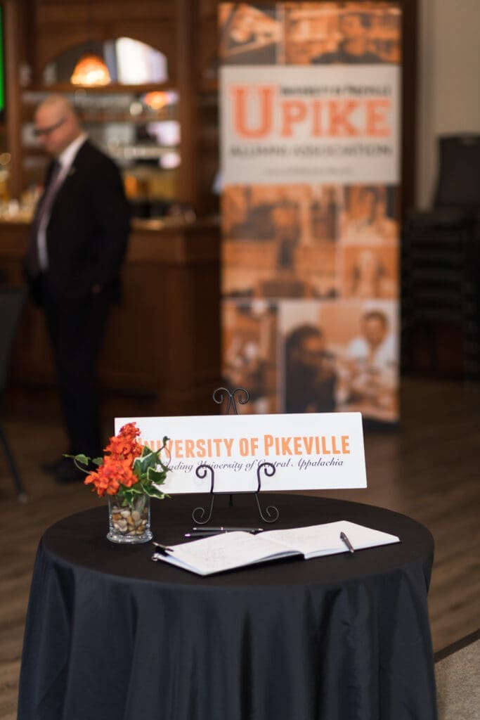 welcome table with a sign in book and UPIKE sign
