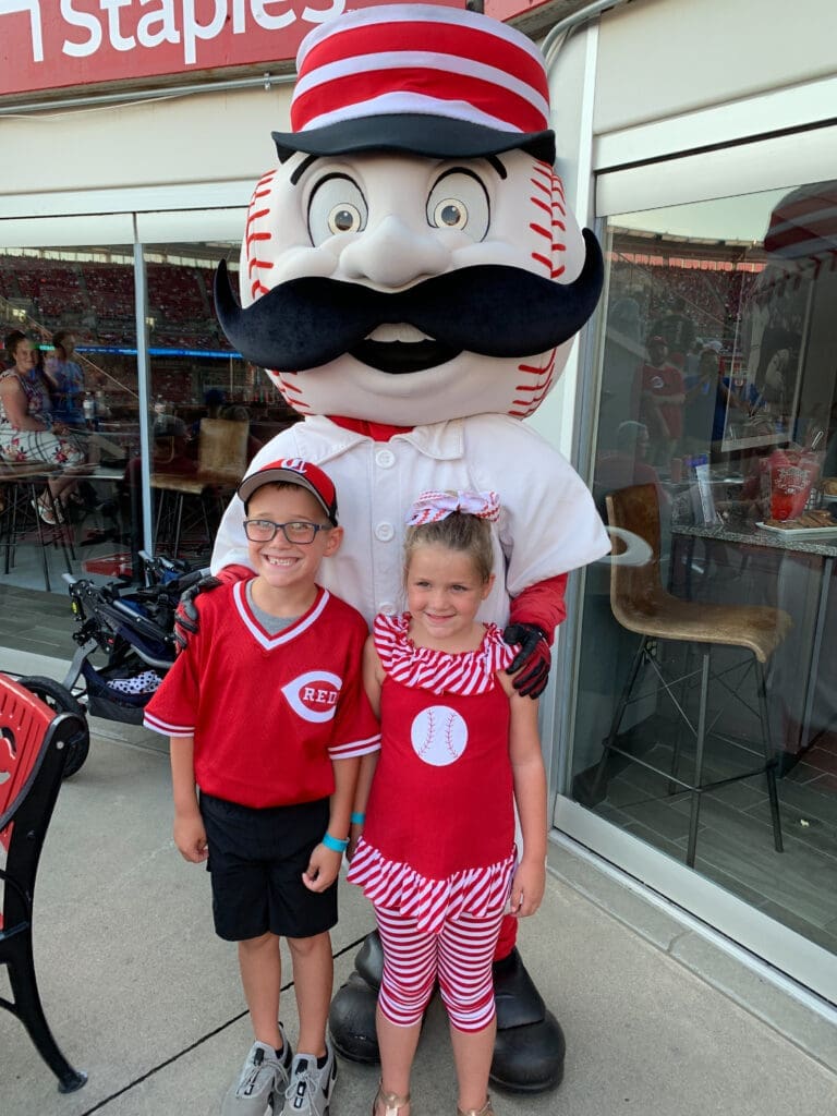 Two children with Reds mascot