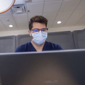 Nursing student studying on his laptop.