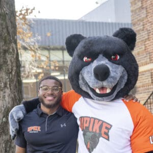 Student posing with Pikey the Bear