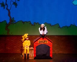 student performs as snoopy during a charlie brown play on campus
