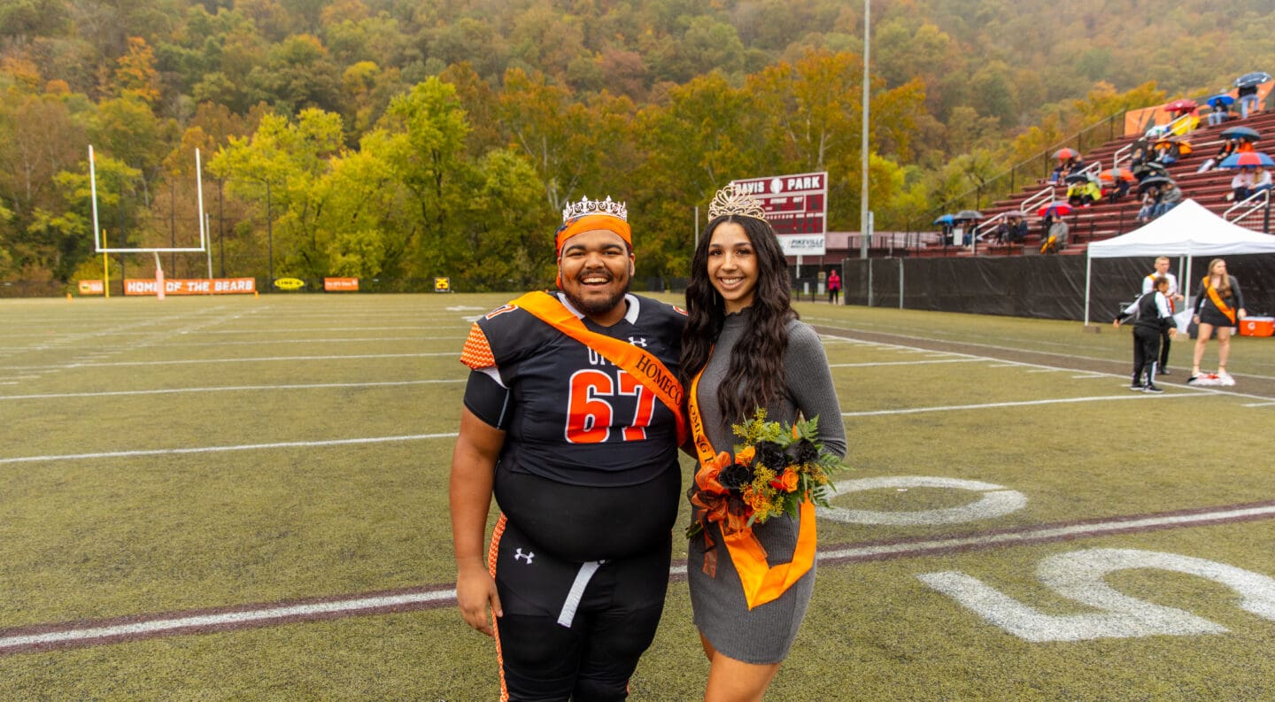 UPIKE Homecoming King and Queen posing on the field