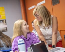 student in education class talks to professor