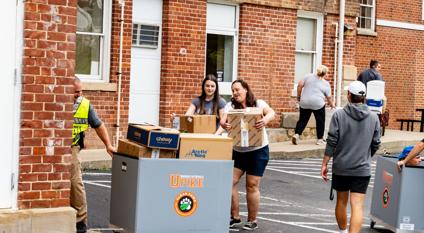 families helping freshmen move in to campus