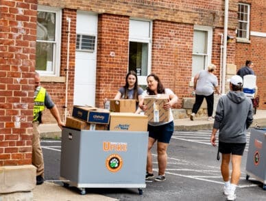 families helping freshmen move in to campus