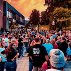 a large crowd gathers outside for the climb