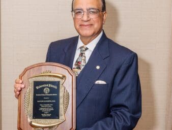 Dr. Rakesh Sachdeva holding the commemorative plaque