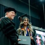 Graduating student, Daniela Hernandez, accepts her diploma from President Webb.