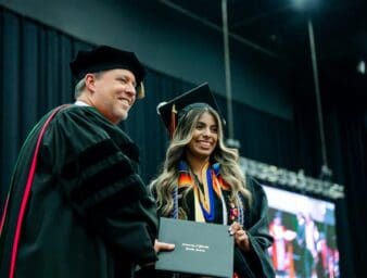 Graduating student, Daniela Hernandez, accepts her diploma from President Webb.