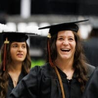 UPIKE Students walking in graduation cap and gown at the university's commencement.