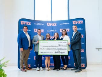 UPIKE leadership and Delta Dental representatives holding and oversized check.