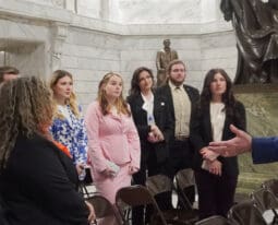 A group of people gathered in a grand interior setting.