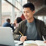 Young man seated in front of a laptop.