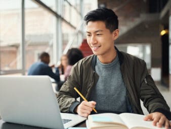 Young man seated in front of a laptop.