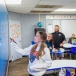 Student writing on smart board