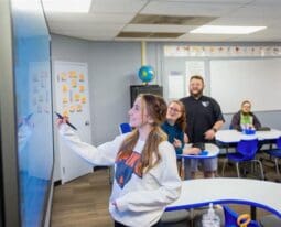 Student writing on smart board