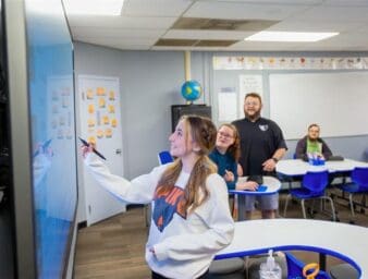 Student writing on smart board