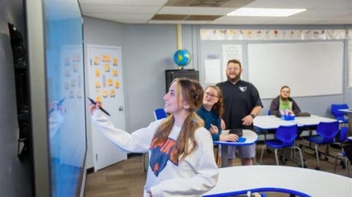 Student writing on smart board