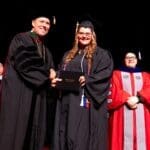 New graduate, Haley McKinney accepting her diploma from UPIKE President Burton Webb