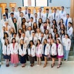 KYCO Class of 2028 posed posed together on stairs for group photo.